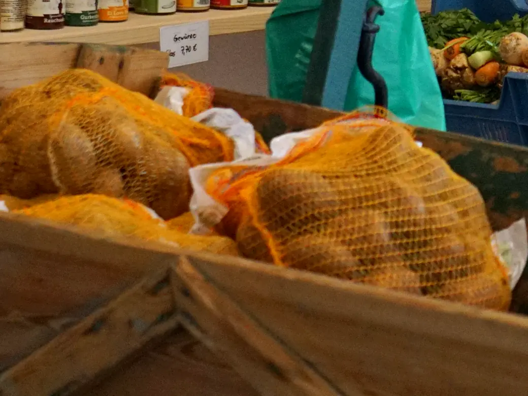 Kartoffeln in Netzen im Handwagen des Hofladens