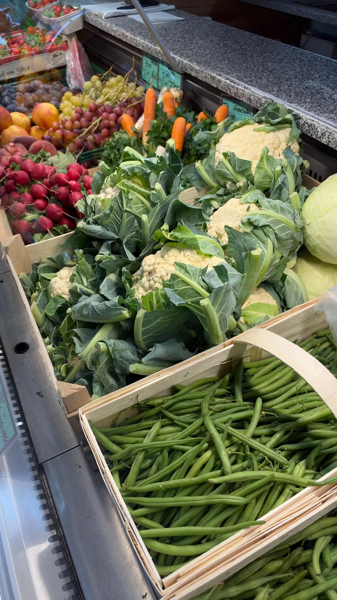 Radieschen, Blumenkohl und frische grüne Bohnen in Holzkisten