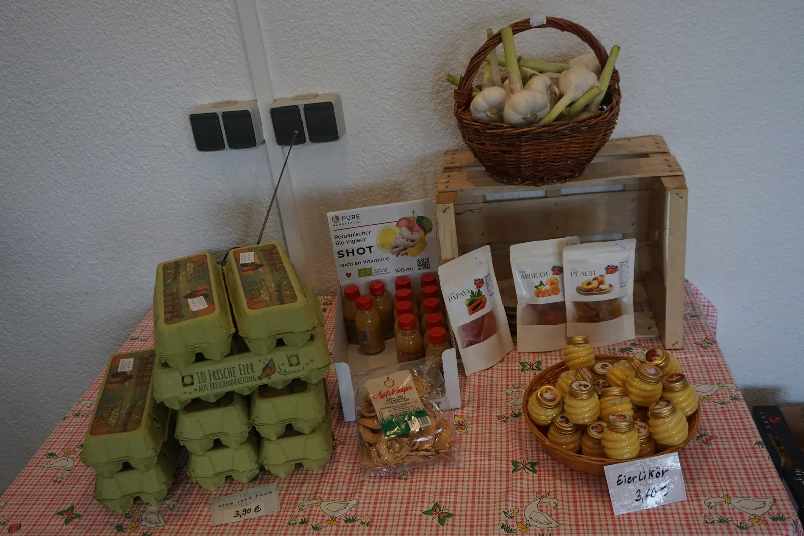 Frische Eier in Kartons, daneben ein Korb mit Gemüse