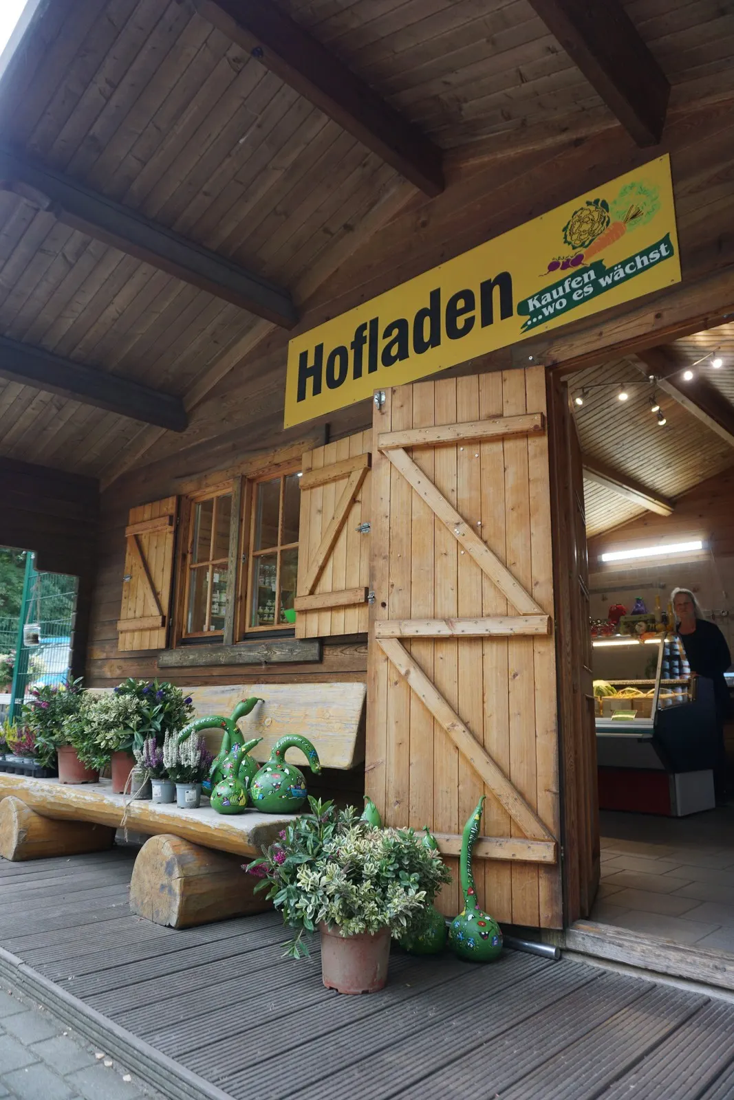 Eingang des Hofladens Lübben mit gelbem Schild „Hofladen“