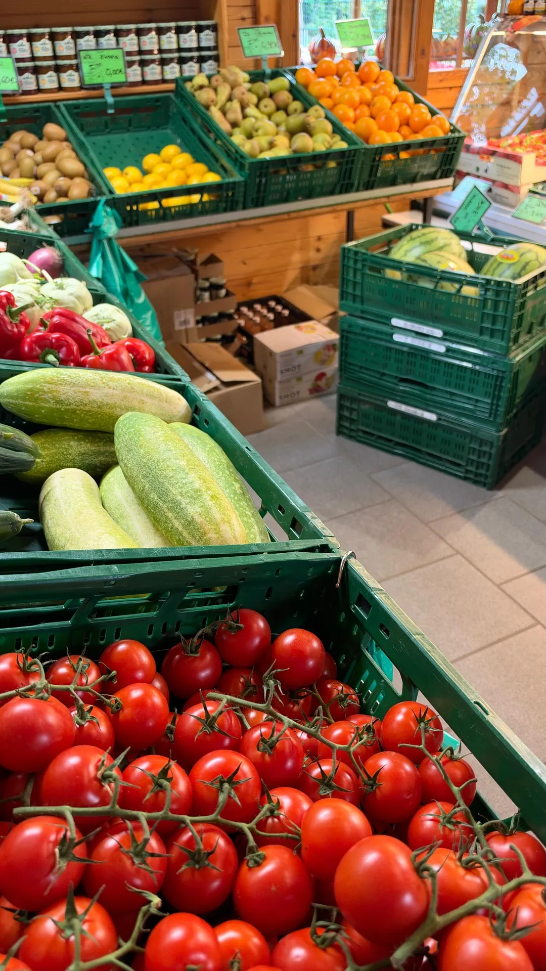 Salatgurken und Rispentomaten, dahinter Kiwis und Zitrusfrüchte